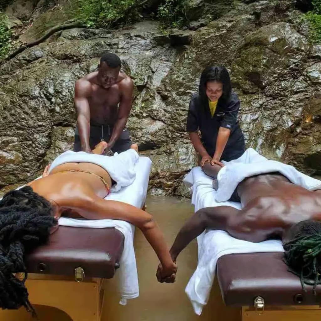 Couple enjoying outdoor massage by the waterfall